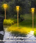 4 Pack Outdoor Solar Torch Lights With Flickering Flame Waterproof Garden Tiki Torches illuminating a wet backyard path