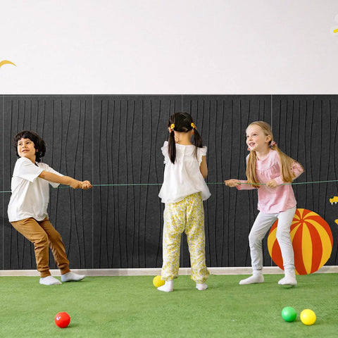 Children playing with a string in front of 6 Pack Acoustic Wall Panels 47.2 By 23.6 Inches Black Sound Proof Panels.