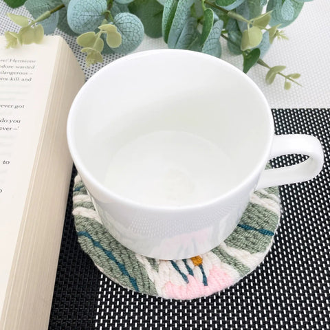 White cup on floral coaster from Punch Needle Coaster Kit With 6 Dope Floral Patterns, Complete Tool Set, Multicolor Embroidery Threads