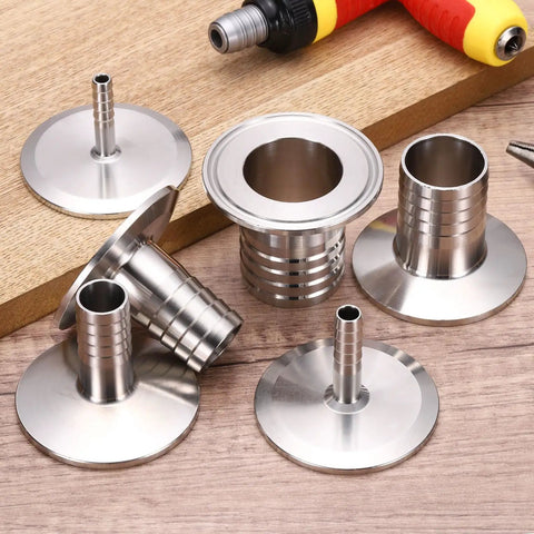 1.5 Inch Tri Clamp To Hose Barb Adapter, Wicked Strong Sus304 Stainless Steel Sanitary Fitting, Badass Connector For Home Brew Beer Wine Distillation Setup, Heavy Duty Pipe Joiner Tool on wooden surface.