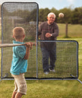 Child batting in front of L Screen Baseball Pitching Net With Wheels, 7x7 Ft Heavy Duty Portable Steel Frame outdoors