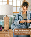 Woman using phone beside Set Of 2 Rattan Table Lamps For Living Room With USB Ports, 27 Inch Tall Rustic Seagrass Bedside Lamps