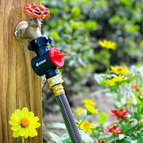 Inline Water Filter For Garden Hoses And Tools Anti Rust Stainless Steel 50 Mesh Screen attached to outdoor faucet with flowers