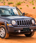Black SUV on a desert road with "New York Jets" plate, showcasing a sporty vehicle in a rugged environment.