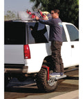 Person using Heavy Duty Tire Step For Trucks And SUVs, 300 Lb Capacity, Non Slip Cheese Grater Steel Surface, Universal Fit For Tires Up To 13 Inches Wide, Height Adjustable, Folds Flat For Easy Storage, Reach Roof Racks And Engine Bay on truck tire