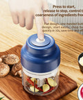 USB Rechargeable Mini Food Processor 320ML With 6 Stainless Blades Electric Garlic Chopper being operated with a finger on the button.