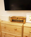 Large Wooden Cable Management Box For Home And Office on a pine dresser next to a photo frame and another cable organizer.