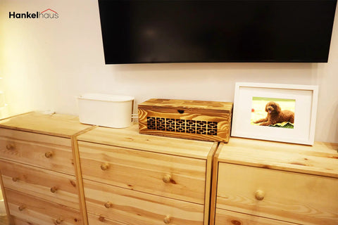 Large Wooden Cable Management Box For Home And Office on a pine dresser next to a photo frame and another cable organizer.