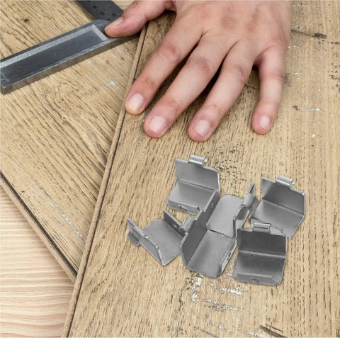 Heavy Duty Freezer Shelf Clips And Refrigerator Support Brackets Set 50 Pieces in metal on a wooden surface with a hand nearby.