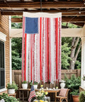 Vintage American Flag Rag Ribbon Banner For Fourth Of July Decor hanging on a porch; 4x2.3 ft size, rustic style.