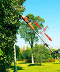 Person using Beefy 2 In 1 Electric Pole Hedge Trimmer With Telescoping Reach to trim tall hedge, showing 6-9 ft extension.