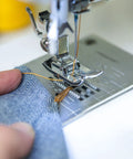 Close-up of sewing machine using Heavy Duty Jeans Sewing Thread 1500 Yards 20s 2 Polyester Spool for denim stitching