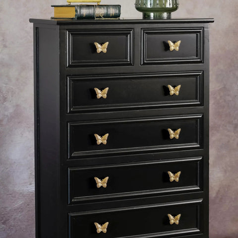 2 Pack Butterfly Cabinet Knobs In Gold Pewter With Delicate Wings And Lifelike Antennae Bringing Whimsical Vibes To Girls Room Dresser Vanity Hardware on a black dresser.