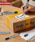 Person using Bulk 48 Count Permanent Markers With Dual Width Chisel Tips Quick Drying Waterproof Ink on shipping box label