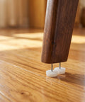 Wooden chair leg on hardwood floor with 100 Pack Nail-In Furniture Glides 0.94 Inch for Hardwood Floors, Plastic Feet, No Slip Glide