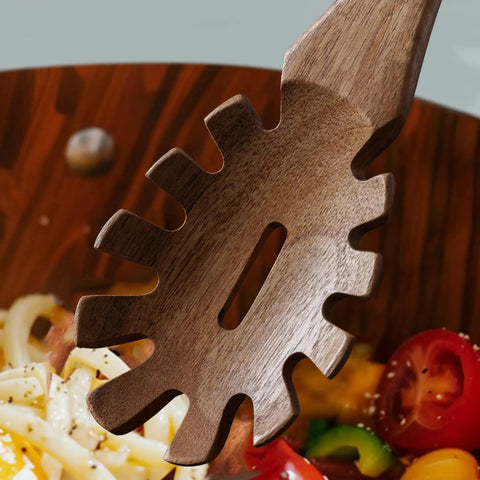 Close-up of the teethed pasta spoon from the Three Piece Acacia Wood Spatula Set For Cooking in a bowl with ingredients.