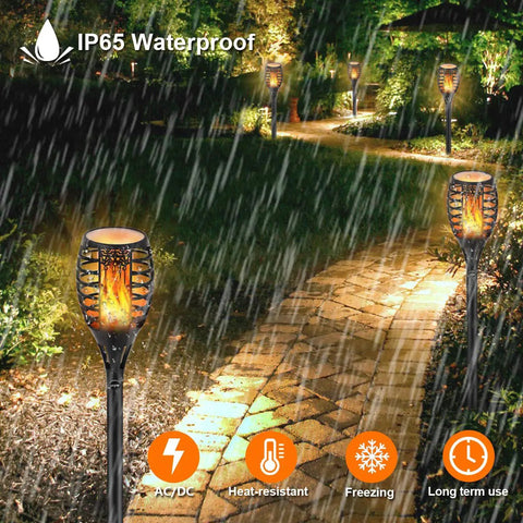 Low Voltage 12V Outdoor Torch Lights Set With Wired LED Flame Torches, IP65 Waterproof Landscape Pathway Lamps shown in garden.