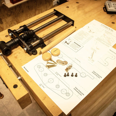 Nine Inch Quick Release Workbench Front Vise With Heavy Duty Cast Iron Body on table with assembly instructions and hardware.