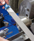 Machinist using 10 Inch Machinist File Set 5 Piece Second Cut And Cross Cut For Universal Roughing And Finishing with blue handle