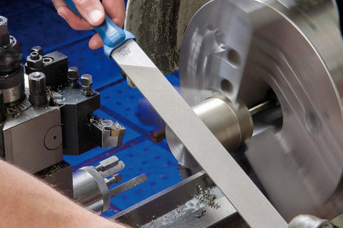 Machinist using 10 Inch Machinist File Set 5 Piece Second Cut And Cross Cut For Universal Roughing And Finishing with blue handle