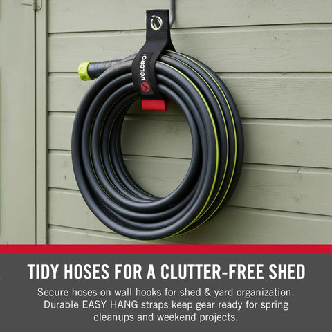 Heavy Duty Extension Cord Organizer With Large 18 Inch Straps For Slick Garage Wall Storage No Mess Setup Built Like A Tank Holds Solid One Hundred Pounds Includes Two Black Packs For Fast Wall Hook Or Nail Mounting, holding hoses neatly on wall with secure straps.