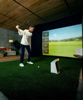 Man using Pro Grade Golf Launch Monitor And Simulator With 10 Inch Color Touchscreen Three Camera System indoors