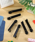 Six Piece Black Zipper Repair Kit for Luggage Backpacks Jackets And More, metal zipper pull replacement sliders on table
