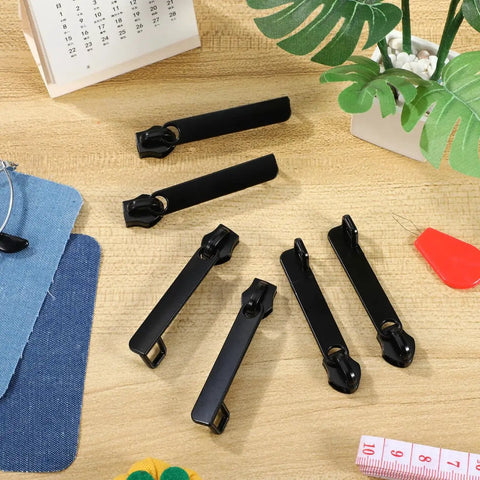 Six Piece Black Zipper Repair Kit for Luggage Backpacks Jackets And More, metal zipper pull replacement sliders on table