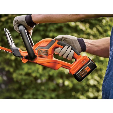 Man holding 40V Max Hedge Trimmer With 22 Inch Dual Action Blade Low Vibration for Smooth Cuts Up To Three Quarters Inch Thick