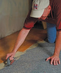 Pro Grade Flooring Underlayment Roll For Laminate Wood And Tile Sound Dampening Padding being installed by a man on the floor.
