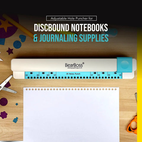 Adjustable 30 Hole Discbound Hole Punch for Custom Planners and Notebooks on wooden table with paper and crafting supplies