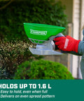 Handheld Lawn And Garden Spreader With Thumb Control Gate, 0.3 Gal Poly Hopper in use dispersing seeds in a garden