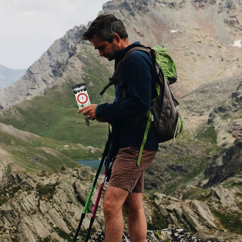 Hiker with Orienteering Compass With Ruler And Mirror For Camping And Hiking, Glow In The Dark Portable Navigation Tool on a mountain
