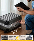 Carry-on luggage with spinner wheels, 20-inch charcoal aluminum-frame hard-shell case beside a person holding a tablet.