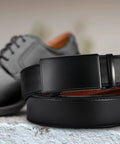 Mens Leather Ratchet Belt With Easy Release Buckle Adjustable Fit Up To One Fifth Inch Increments 35mm Wide next to black shoes