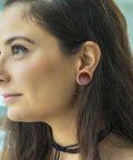 Person wearing Organic Wood Ear Gauges Set, 6 Pieces, Double Flared Saddle Plugs Stretcher for Punk Piercing, Brown and Black Teak Finish