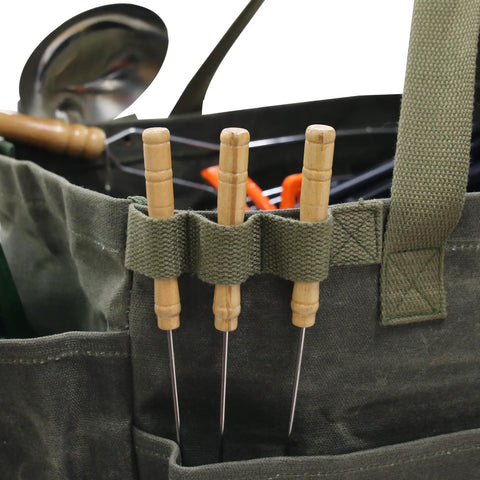 Close-up of army green Waxed Canvas Firewood Carrier Tote For Camping And Garden Work with tools in pockets
