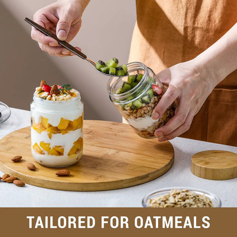Four Pack 16 Oz Glass Jars With Airtight Lids And Bamboo Lids For Overnight Oats Meal Prep And Grab And Go Snacks Yogurt Spices Sugar And More Wide Mouth Mason Jars on a wooden board with fruits and oats