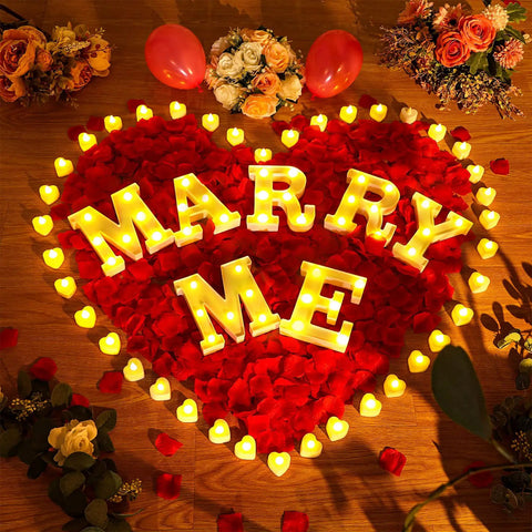 "Marry Me" in lights surrounded by 6000 Artificial Rose Petals And 72 Heart Shaped LED Tealights For Romantic Nights Valentines