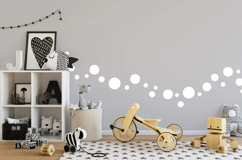 Playroom decorated with 63 White Polka Dot Wall Decals For Kids Rooms And Nurseries, Peel And Stick Vinyl Dots, toys, and shelves.