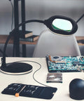 LightView Pro Magnifying LED Desk Lamp With Flexible Gooseneck And 3 In 1 Magnifier on desk with electronics tools