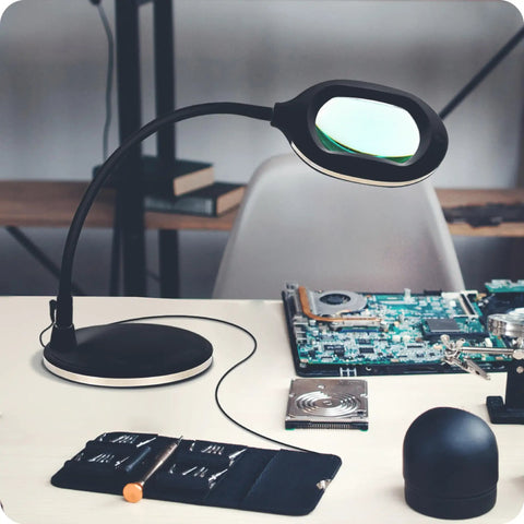 LightView Pro Magnifying LED Desk Lamp With Flexible Gooseneck And 3 In 1 Magnifier on desk with electronics tools