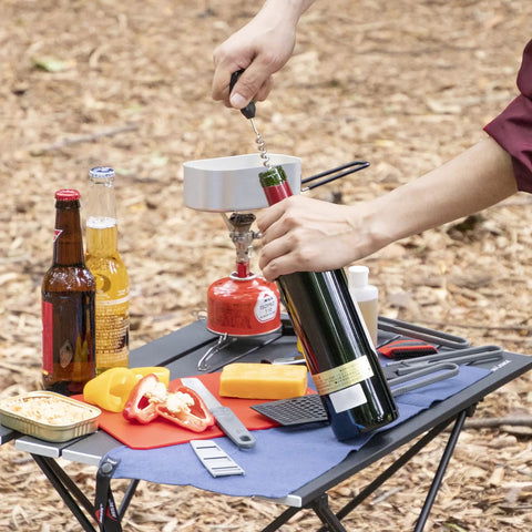 Hiker using Alpine Deluxe Outdoor Kitchen Set With Zippered Carry Case BPA Free Tools on a foldable camping table in woods