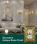 Luxurious living room with decorative antique brass duplex outlet cover plate featuring paisley pattern on wall.