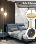 Frosted Glass Globe Floor Lamp With Contemporary LED Lighting In Antique Brass Finish near bed, weighted base details.