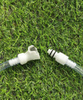 Hose barb inline quick-connect fittings, white plastic, 1 male and 1 female, clear tubing ends on grass