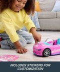 Child playing with Remote Control Pink Convertible RC Toy Car with Dual Driving Modes, customization sticker sheet visible