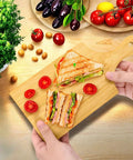 YIMITEE bamboo cutting board with handle, natural wood, 11x5 in; front view with two sandwiches on board.