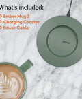 Keep Your Coffee Piping Hot With This App Controlled Smart Mug Featuring A 14Oz Rechargeable Heated Warmer Crisp Led Panel And On Point Temp Controls Total Game Changer For Desk Vibes And Daily Sessions In Fresh Sage Green. Green charging coaster next to a latte art decorated mug on marble surface.