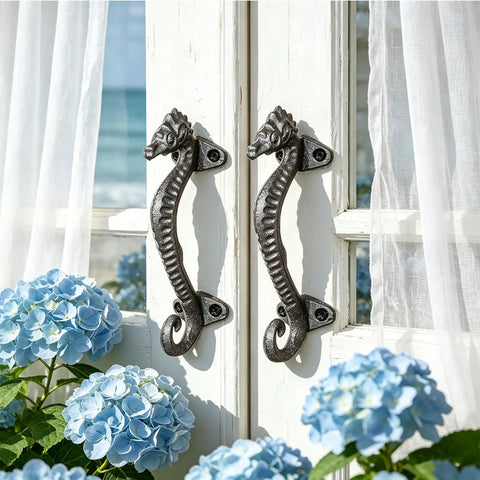 Two Pack Seahorse Cast Iron Door Handles Set on white rustic door, heavy duty pulls for farmhouse, vintage decorative hardware.